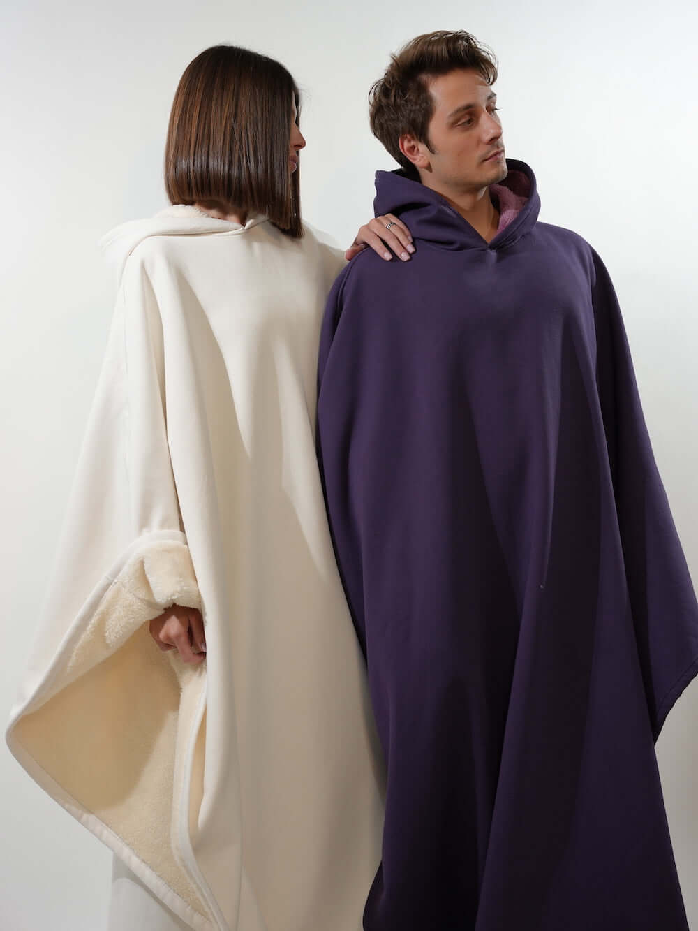 Two models showcasing the Eden Comfort Hoodie Blanket in white and purple, designed for relaxation and stress relief.