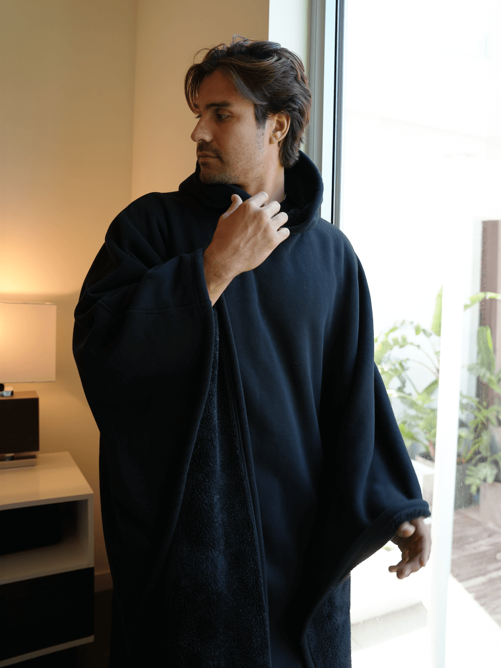 Man wearing the Eden Comfort Hoodie Blanket, showcasing relaxation and cozy style in a modern indoor setting.  Oversized Comfort Hoodie Blanket – Wearable Sherpa Fleece for Cozy Warmth    qykyai-sq.myshopify.com