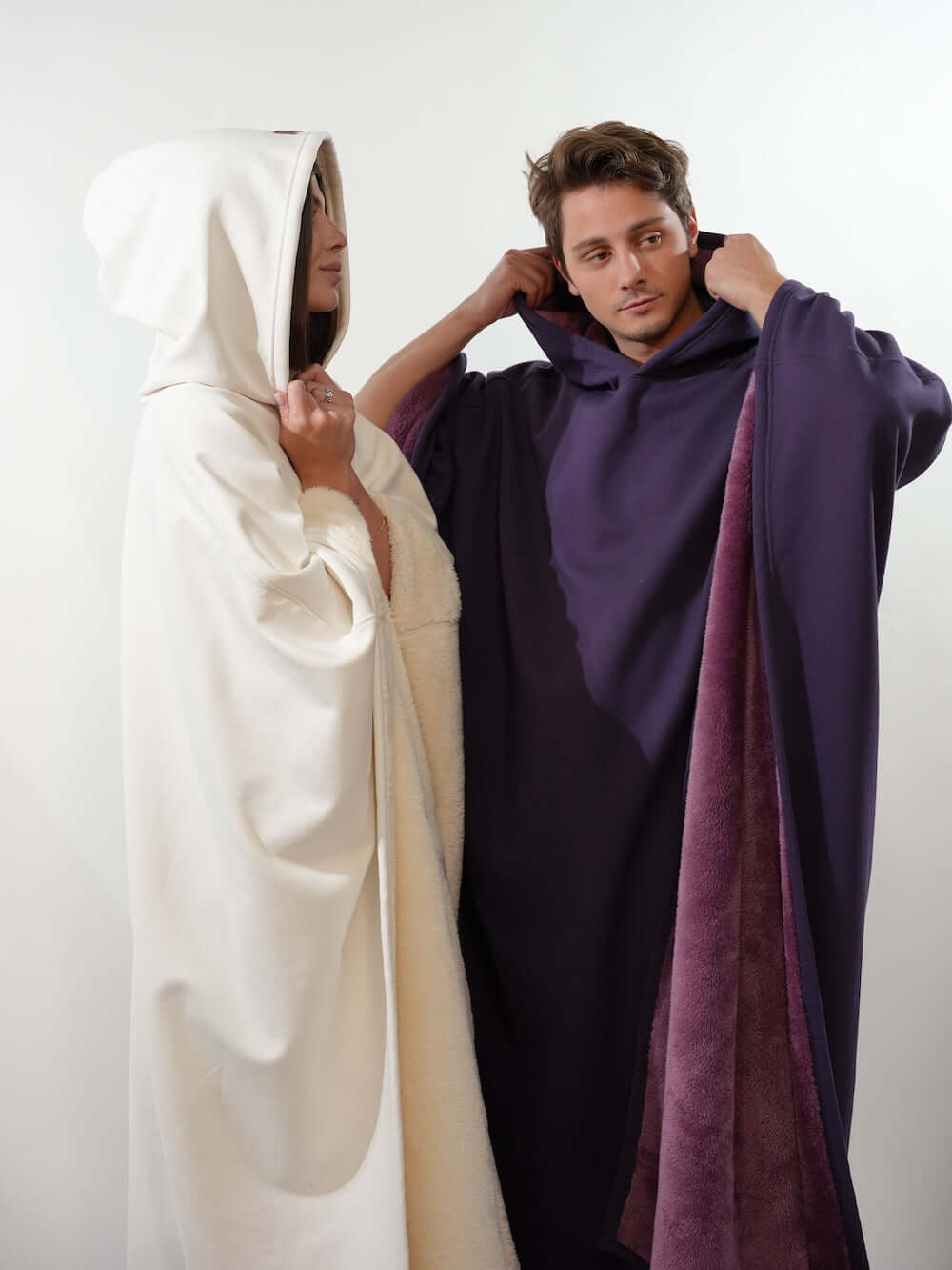 Two individuals wearing Eden Comfort Hoodies, one in white and the other in purple, showcasing cozy, relaxing style.